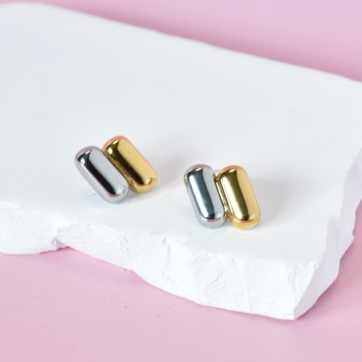 Stylish dual-tone capsule stud earrings in gold and silver