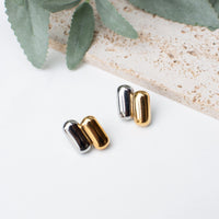 Stylish dual-tone capsule stud earrings in gold and silver