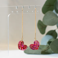 Vibrant heart-shaped earrings with pink and red mosaic design on a gold chain from the Galentine Collection.