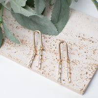 Elegant gold linear drop earrings featuring sparkling crystal accents