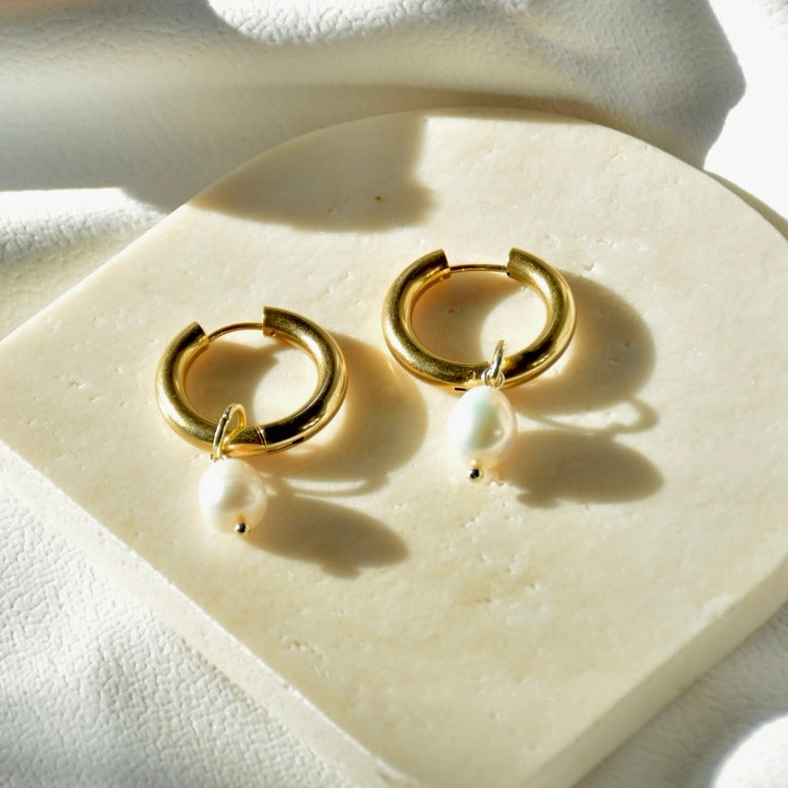 Timeless classic gold hoop earrings featuring elegant pearl drops