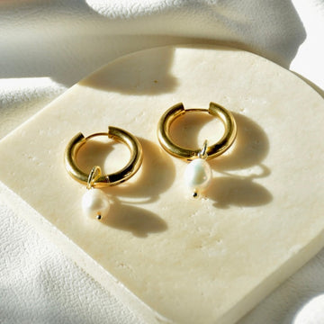 Timeless classic gold hoop earrings featuring elegant pearl drops