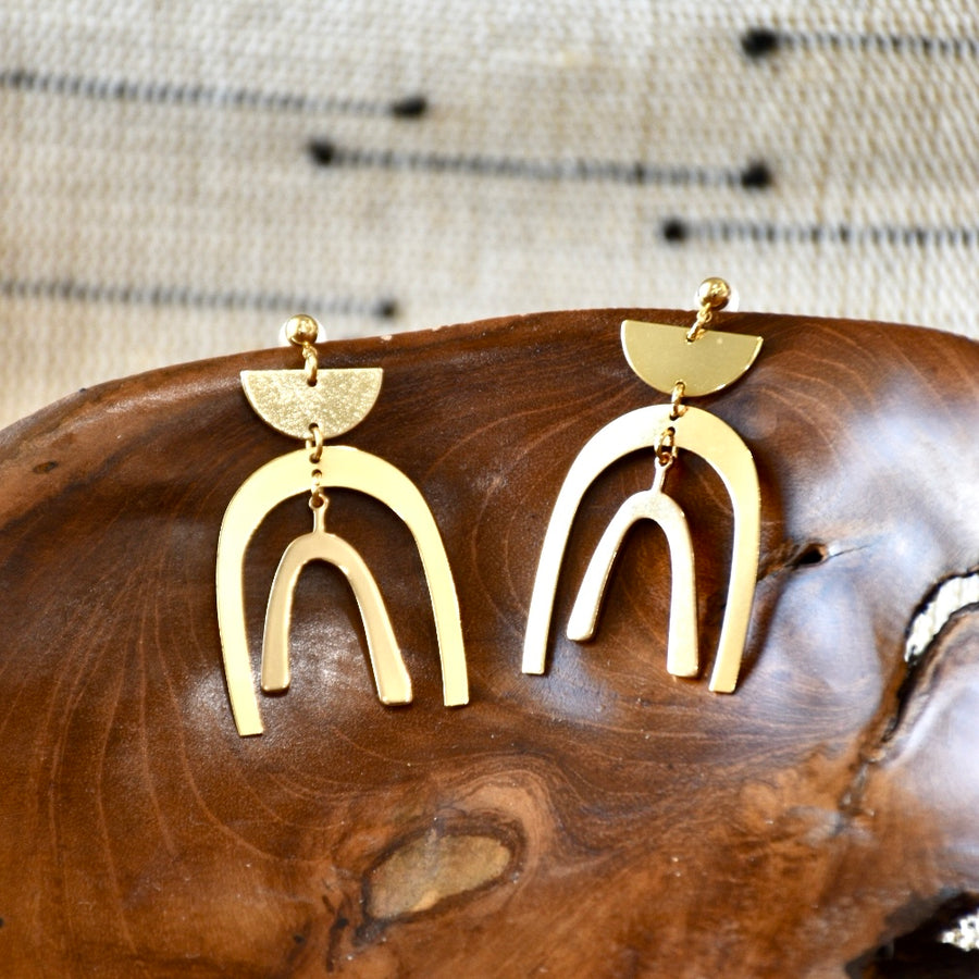 A pair of elegant gold arc earrings with a modern, geometric design