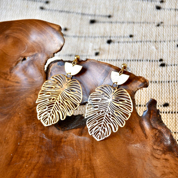 Intricate gold monstera leaf earrings with a delicate, openwork design